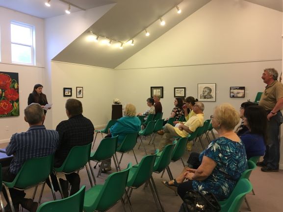 Natasha Wiatr speaks to guests during the opening reception for "The Northern Coney Island" exhibit